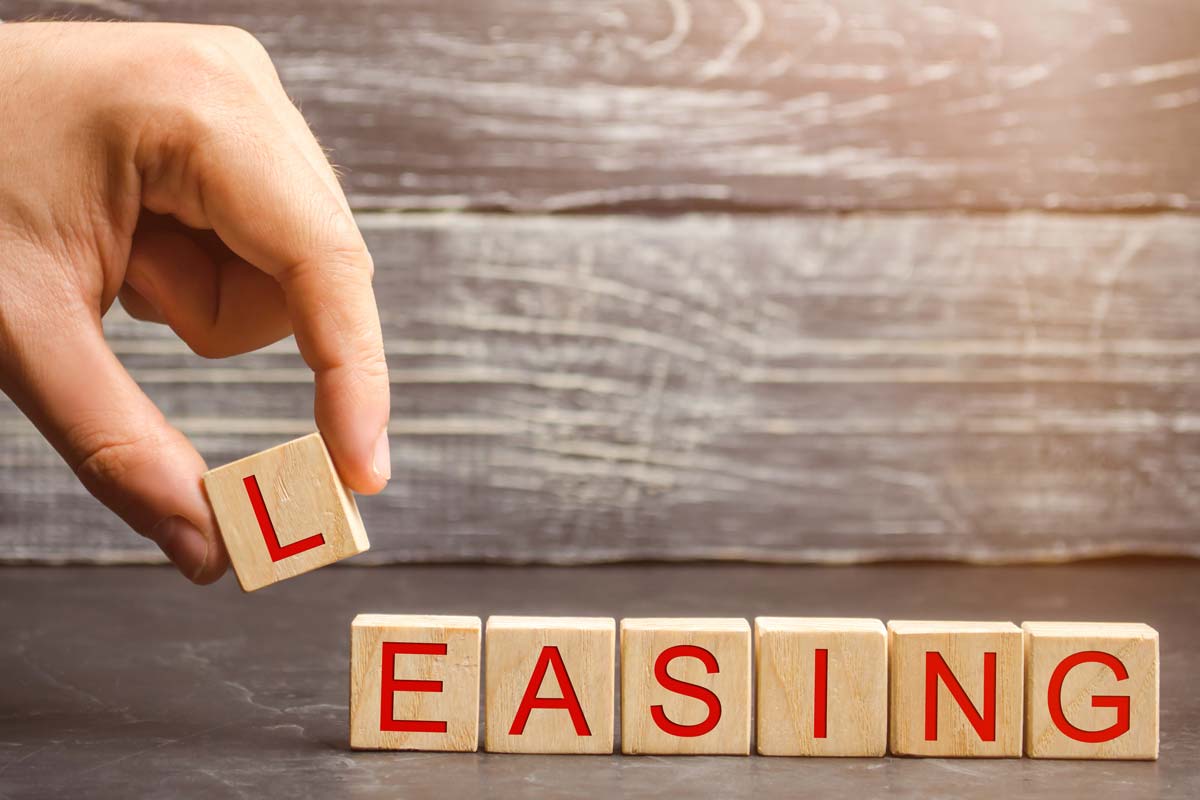 hand placing lettered cubes spelling out the word "leasing"