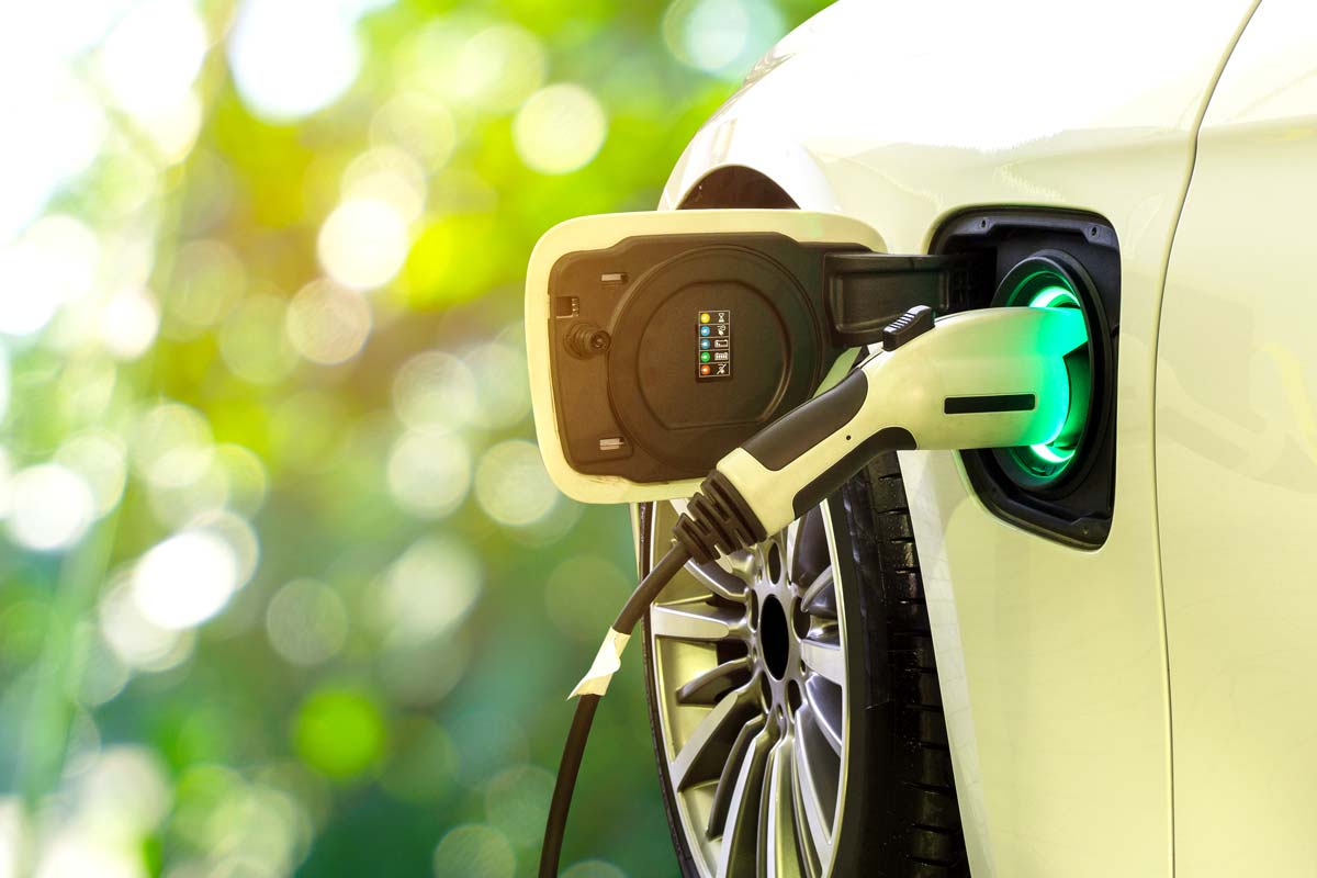 Electric car at charging station with the power cable supply plugged in