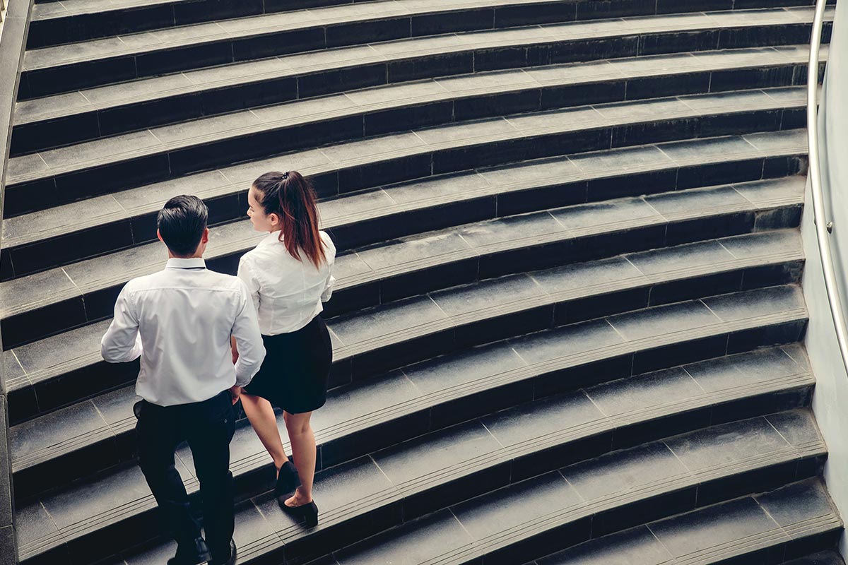 2 businesspeople walking up stairs