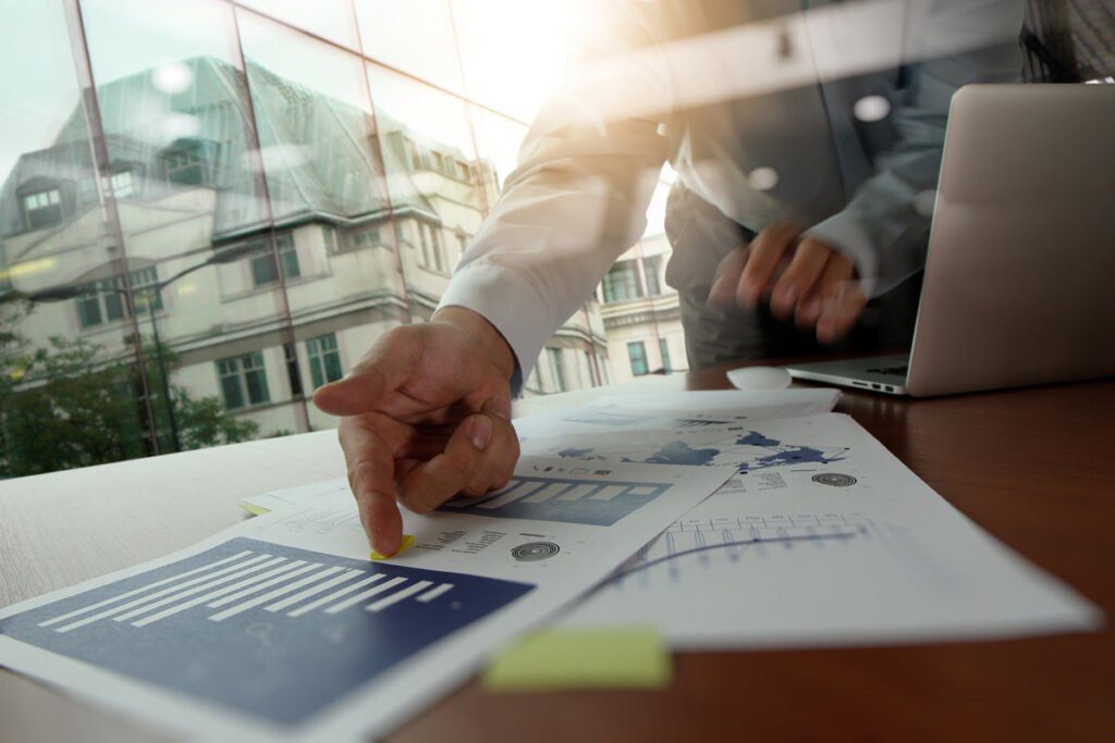 a hand in a button down shirt pointing to a graph