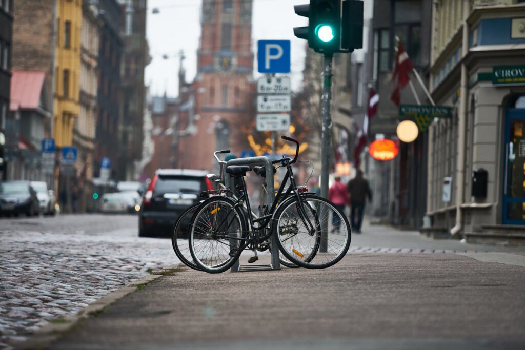 a bike rack with 2 bikes on it on a city block