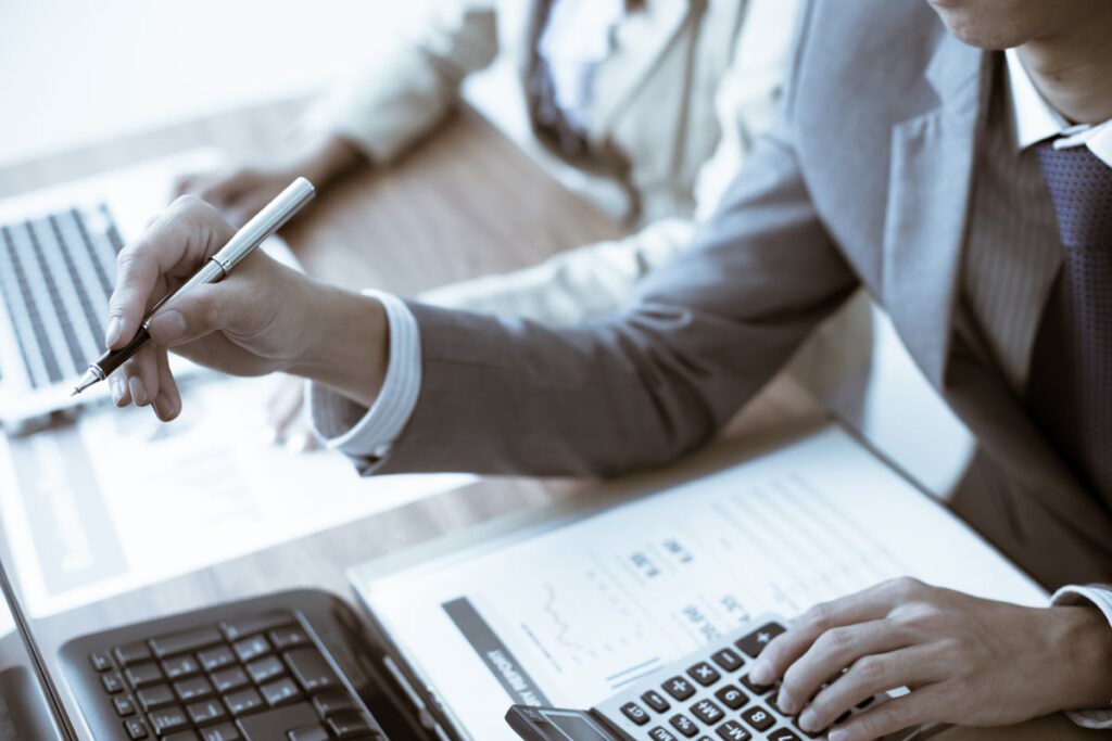 a hand pointing at a computer with a pen