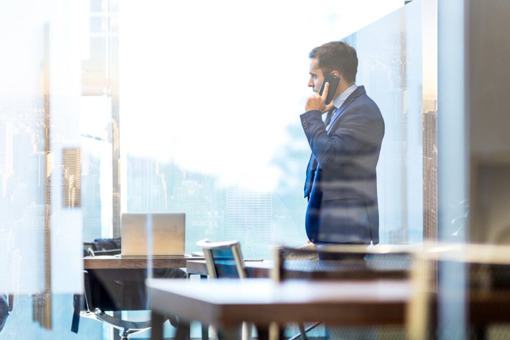 a man in a suit on the phone in an office