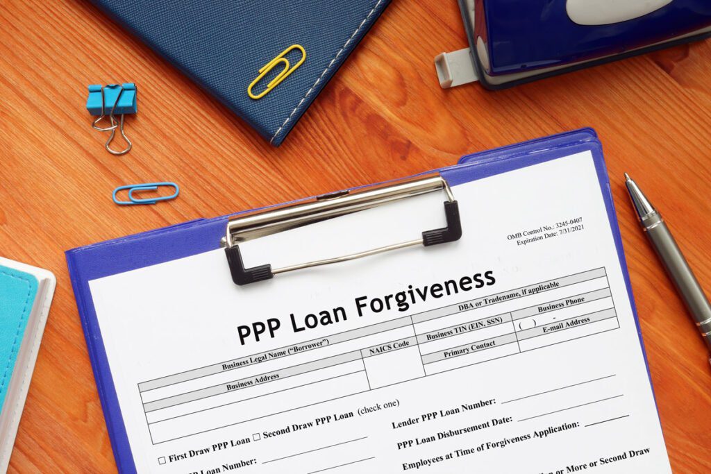 clipboard on a desk with a paper that reads "PPP Loan Forgiveness"