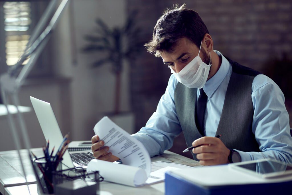 businessman in a mask working at a desk