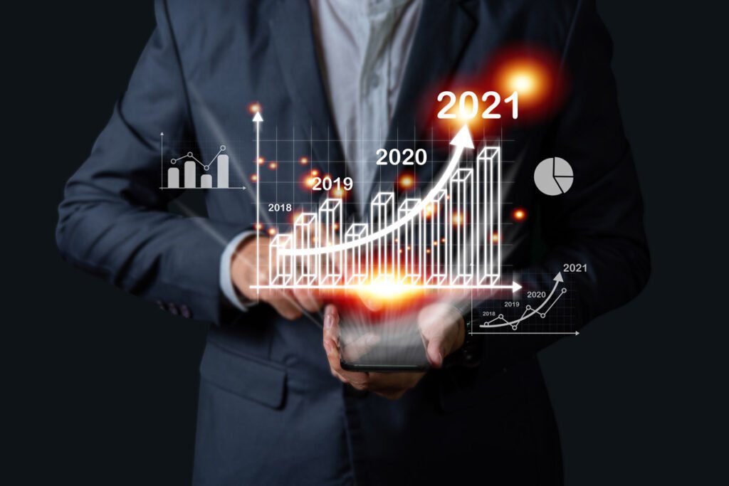 person in suit with a graph in front of them showing increases from 2018-2021
