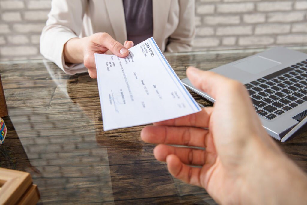 a check being handed to a hand