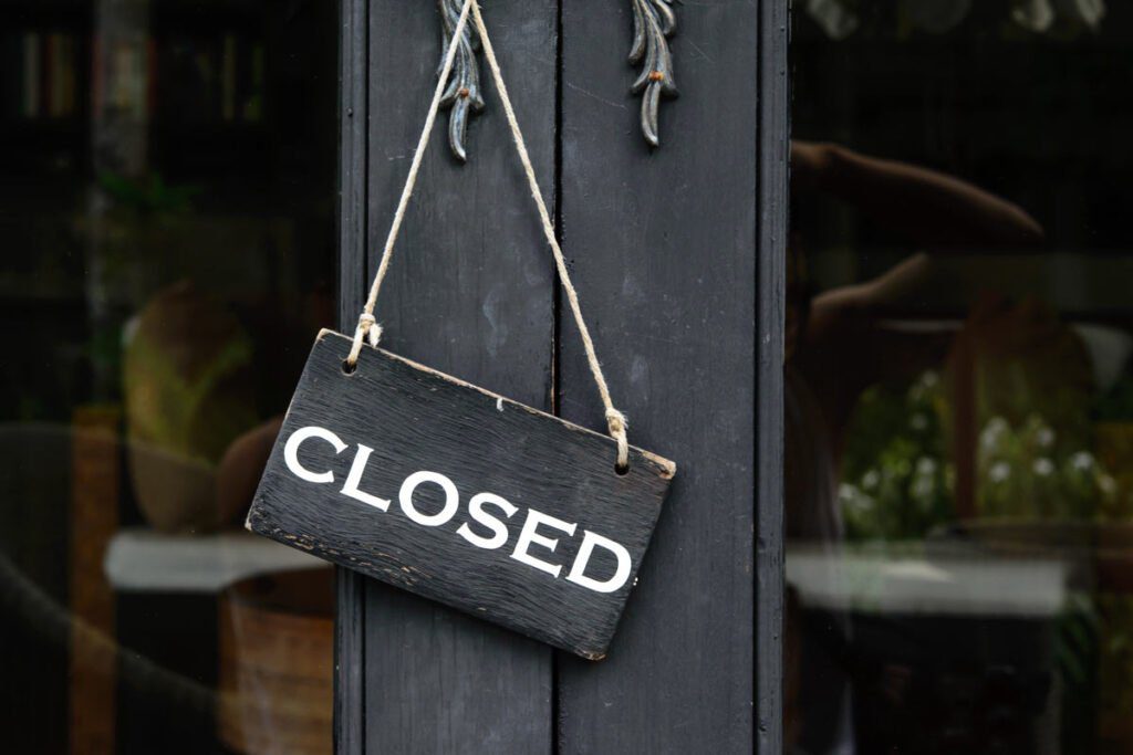 "closed" sign hanging on a shop door