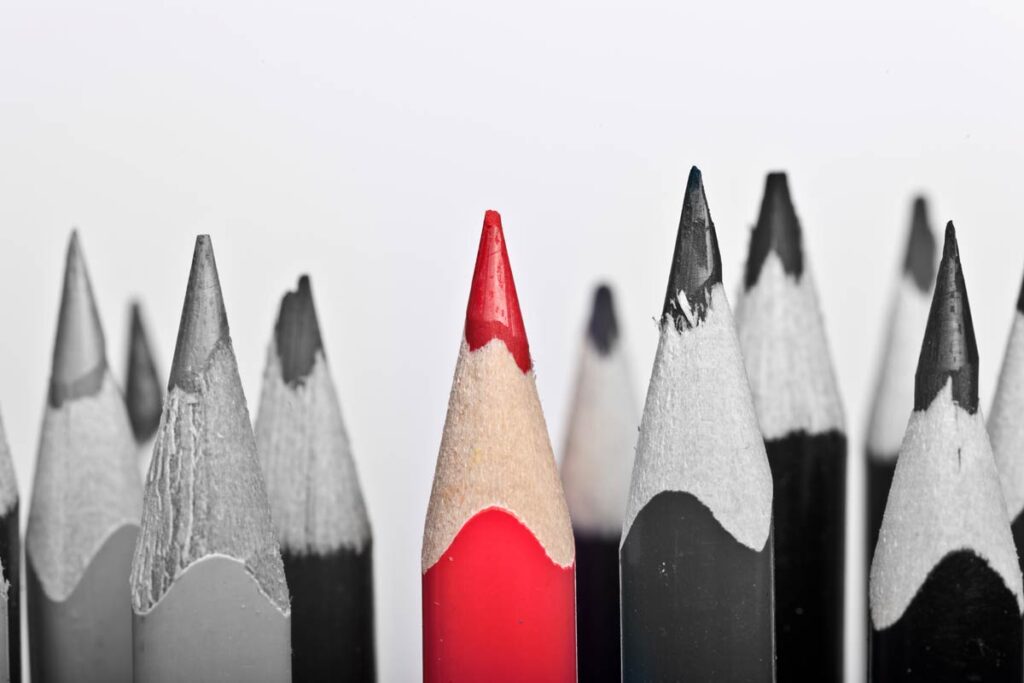 red pencil with black and white pencils around
