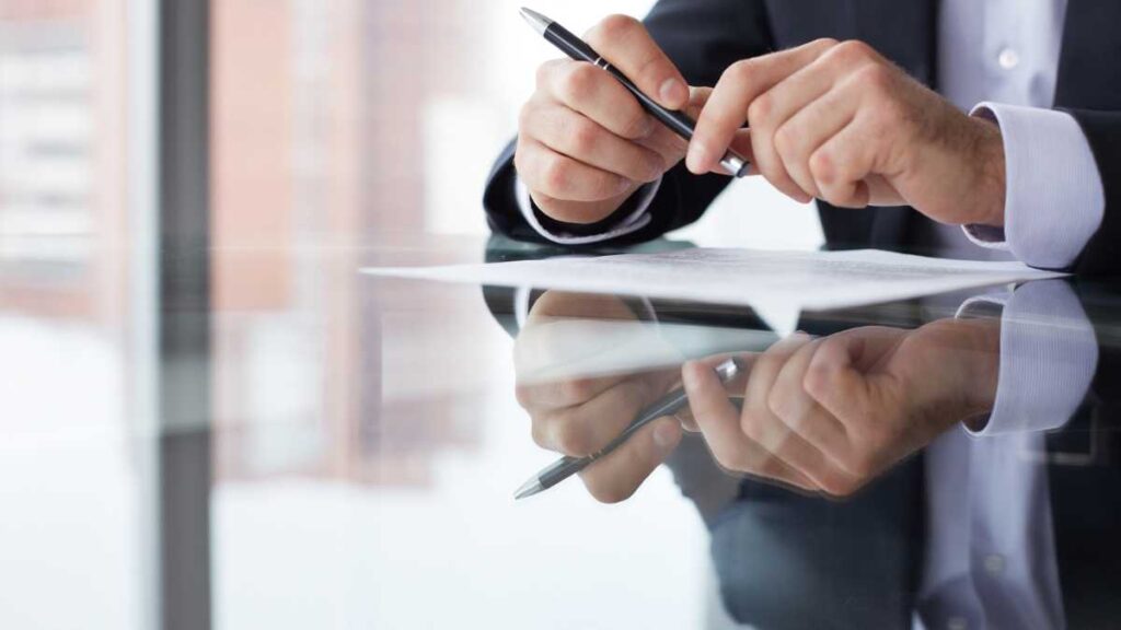 man using pen and looking at paper