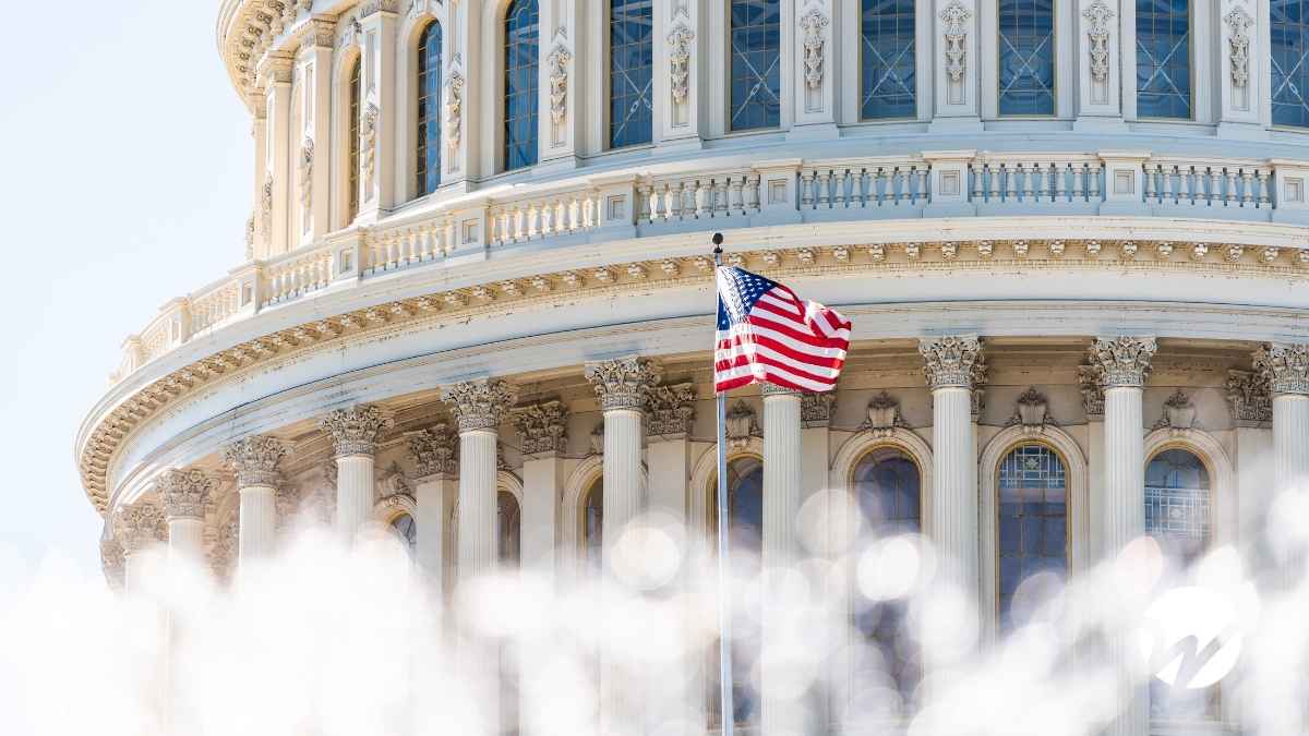 The U.S. Capitol building with an American flag waving in front, symbolizing pending federal legislation.