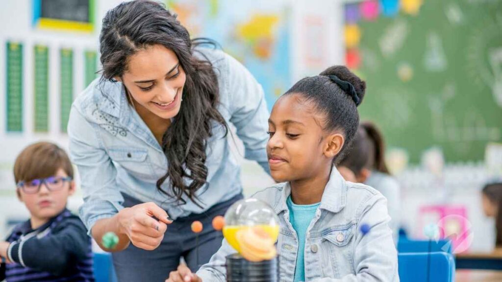 A teacher helping a child with a science experiment