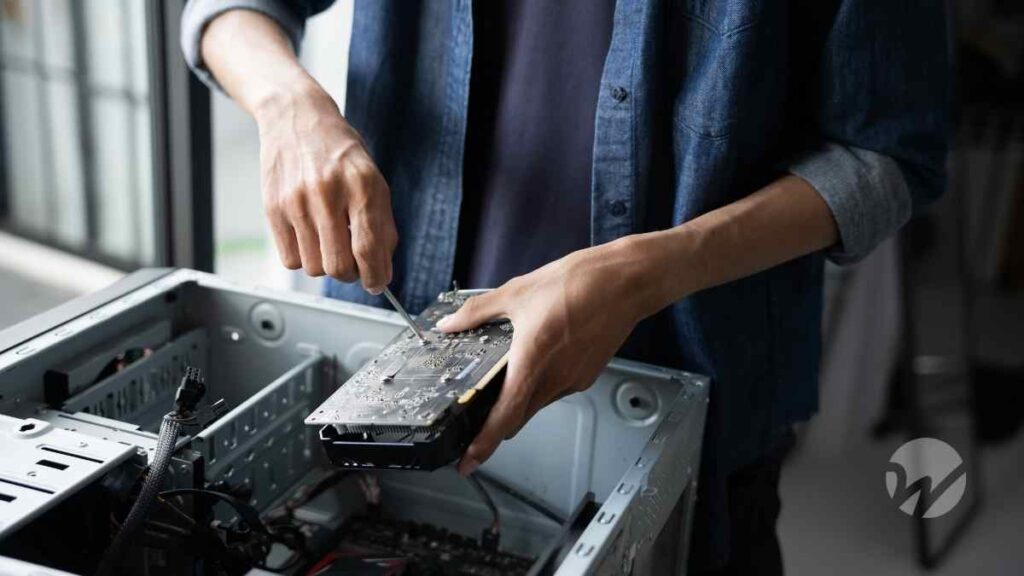 Person installing a computer circuit board inside a desktop case, symbolizing research, technology, and Section 174 tax changes.