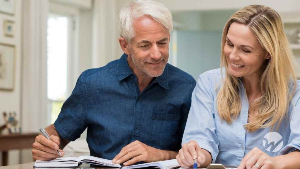 Happy middle-aged couple reviewing various financial documents.