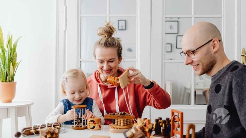 Mom, dad, and child sitting at table playing with blocks