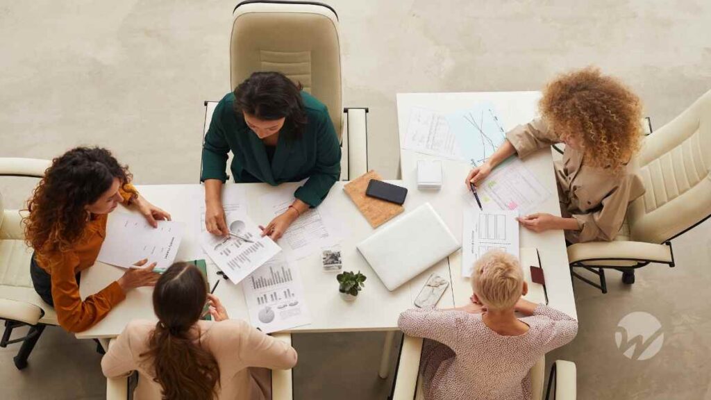 five nonprofit board members at a long conference table going over financial statements