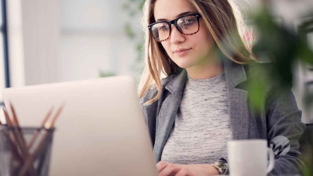 woman in glasses working on a laptop