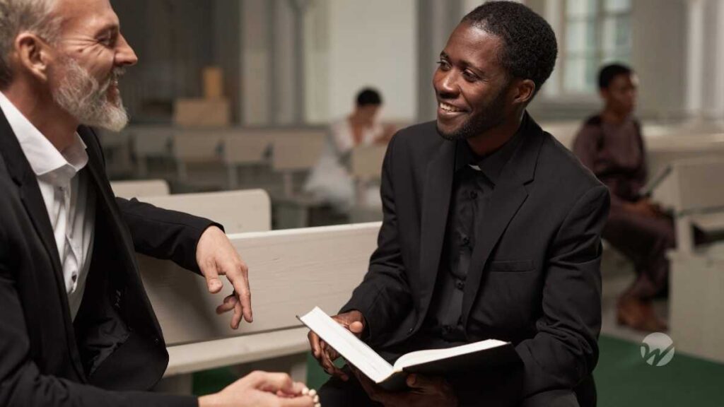 Priest looks over book with parish member