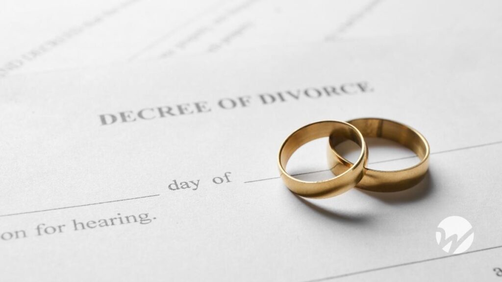wedding rings laying on top of document labeled, "Decree of Divorce"
